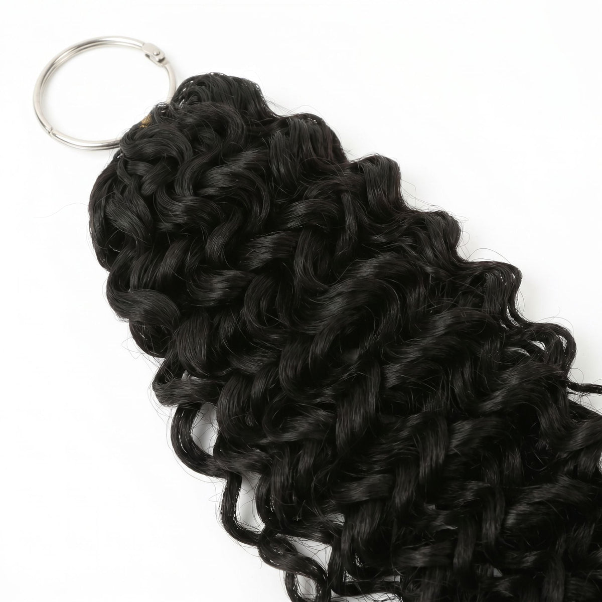 Detail of the metal ring holding the looped top of natural black ocean wave crochet hair extensions on a white background