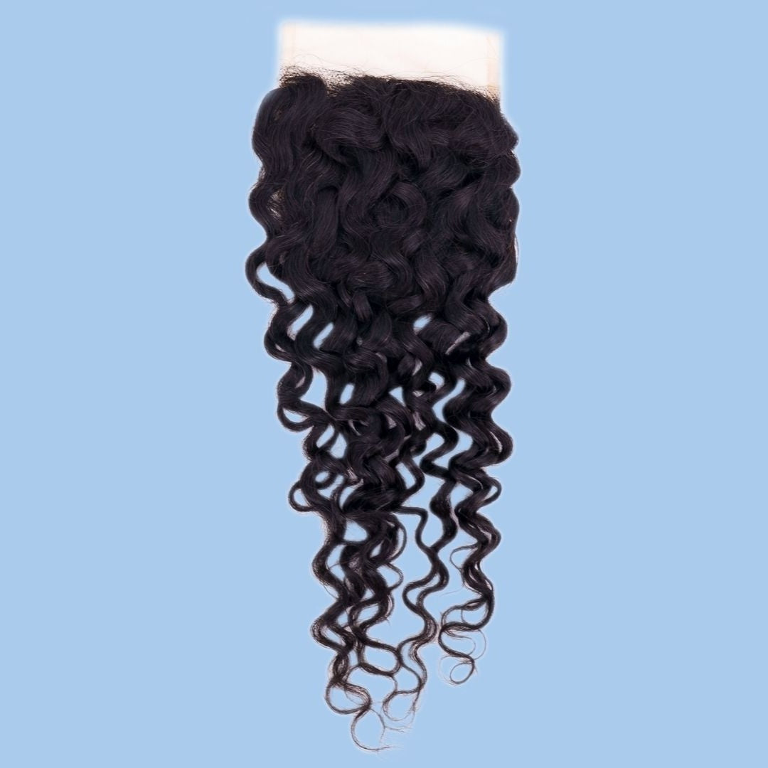 Natural black spiral wave transparent lace closure hair extensions hanging against a blue backdrop with the lace panel at the top