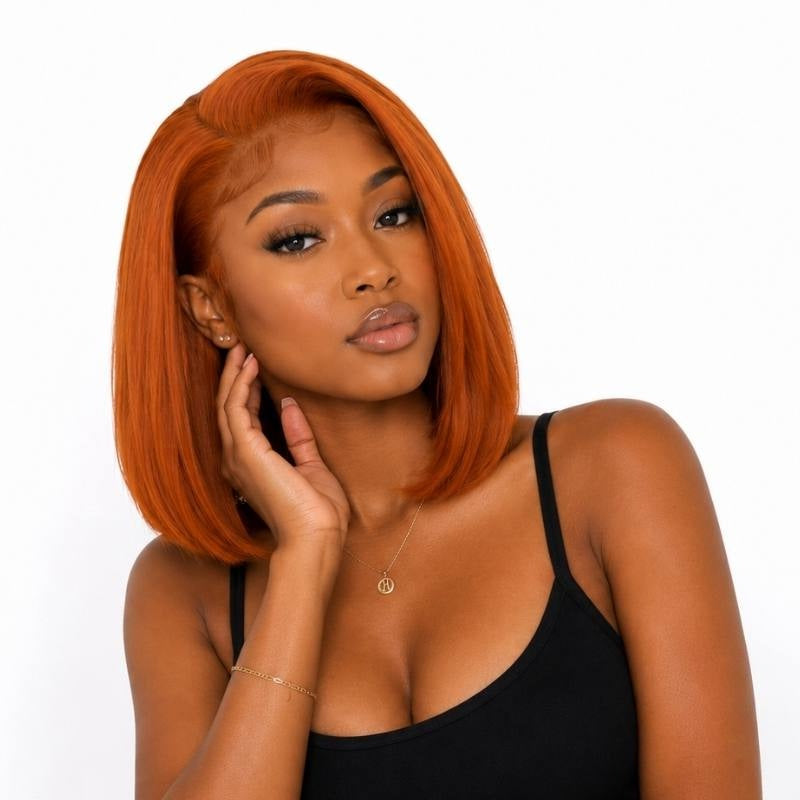 Model resting a hand near her jaw wearing a straight cinnamon orange ginger bob human hair wig with a deep side part