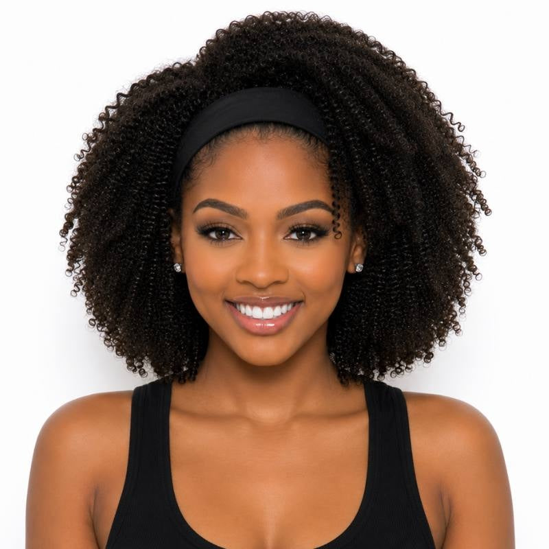 Model smiling to camera wearing an afro kinky curly natural black headband human hair wig with a black stretch band across the hairline