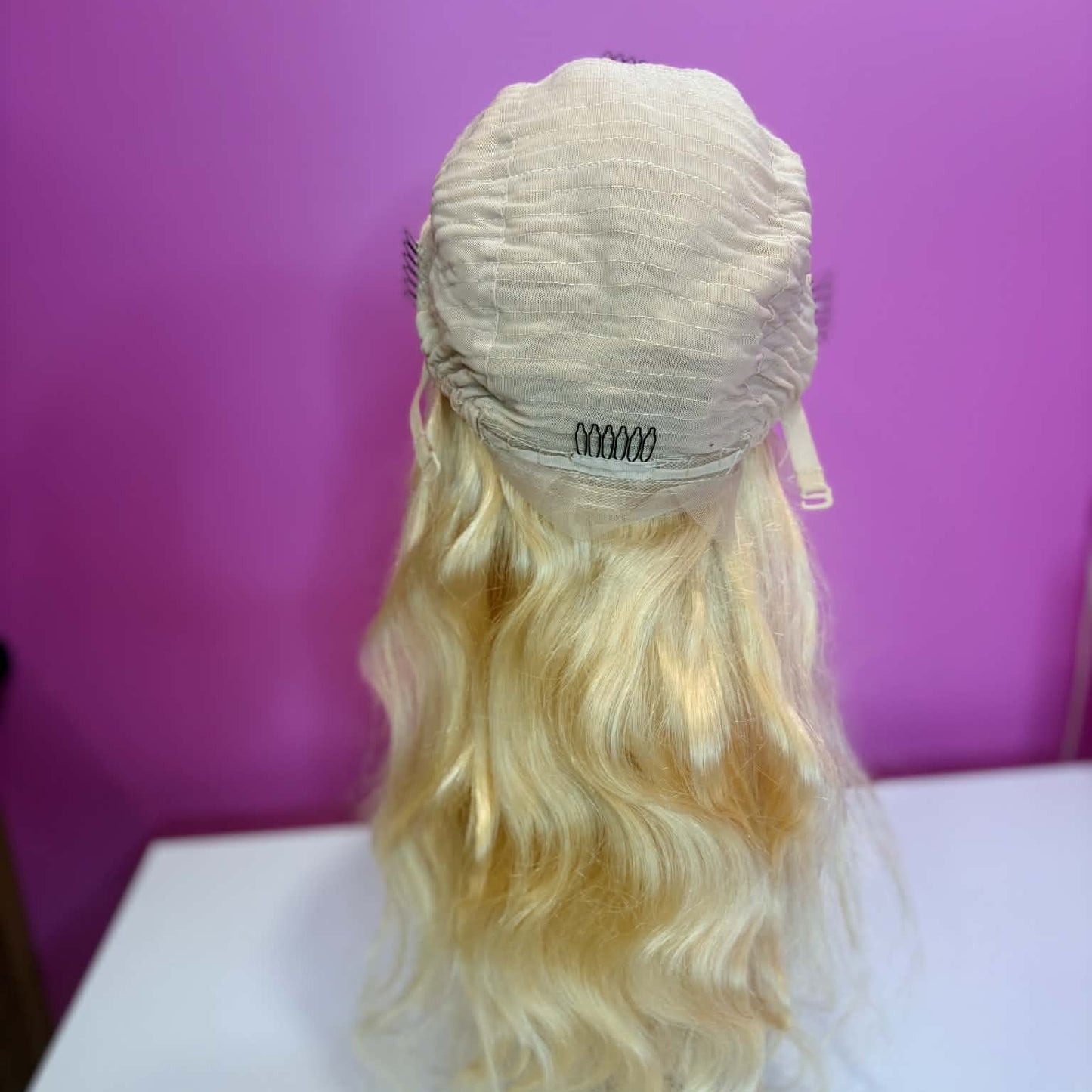 Back cap view of 16 inch blonde 613 body wave 13x4 lace front human hair wig showing adjustable straps and cap construction