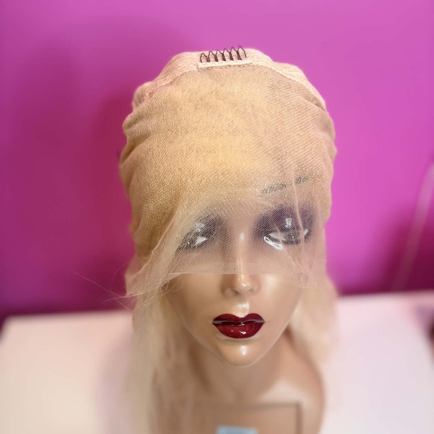 Interior front cap view of 16 inch blonde 613 body wave human hair wig showing 13x4 transparent lace frontal construction