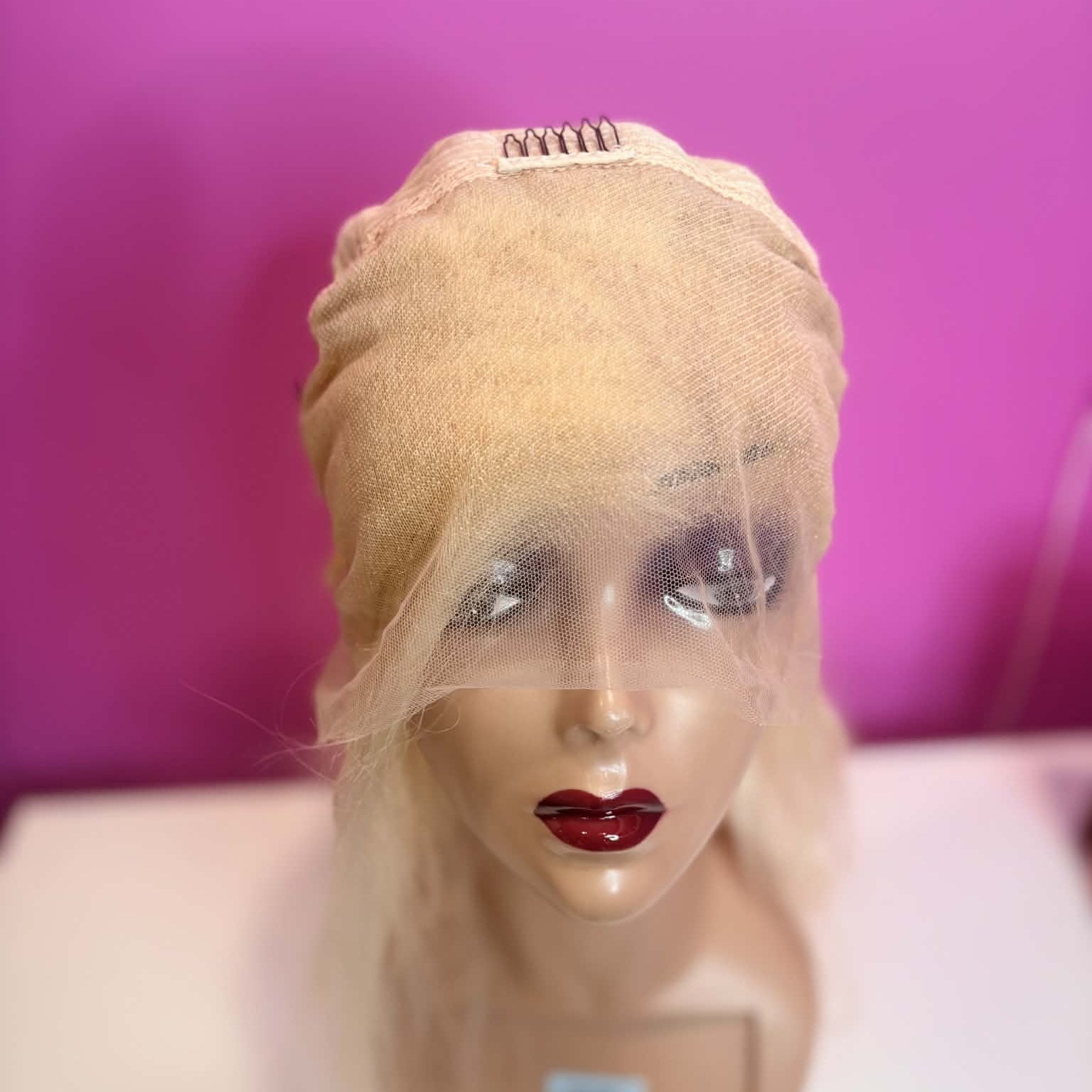 Interior front cap view of 16 inch blonde 613 body wave human hair wig showing 13x4 transparent lace frontal construction