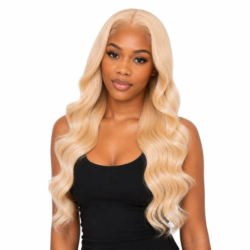 Model facing forward wearing a long blonde body wave human hair wig with a middle part and waves falling over both shoulders