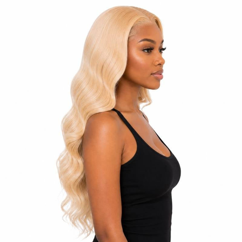 Side profile of a model wearing a long blonde body wave human hair wig with waves running down the back