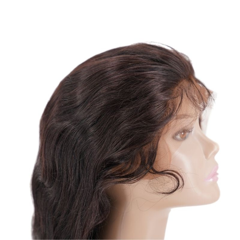 Body wave natural black human hair wig in profile on a mannequin head with the transparent lace hanging uncut across the face