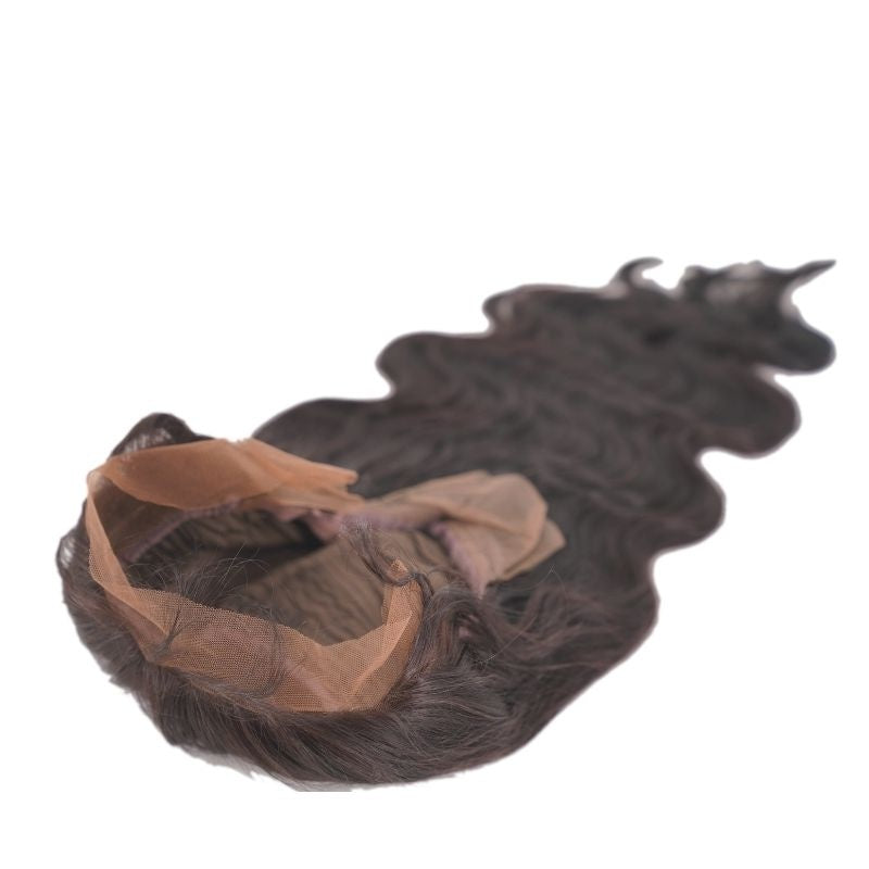 Body wave natural black human hair wig laid flat on white with the transparent lace front folded open and waved hair stretching out