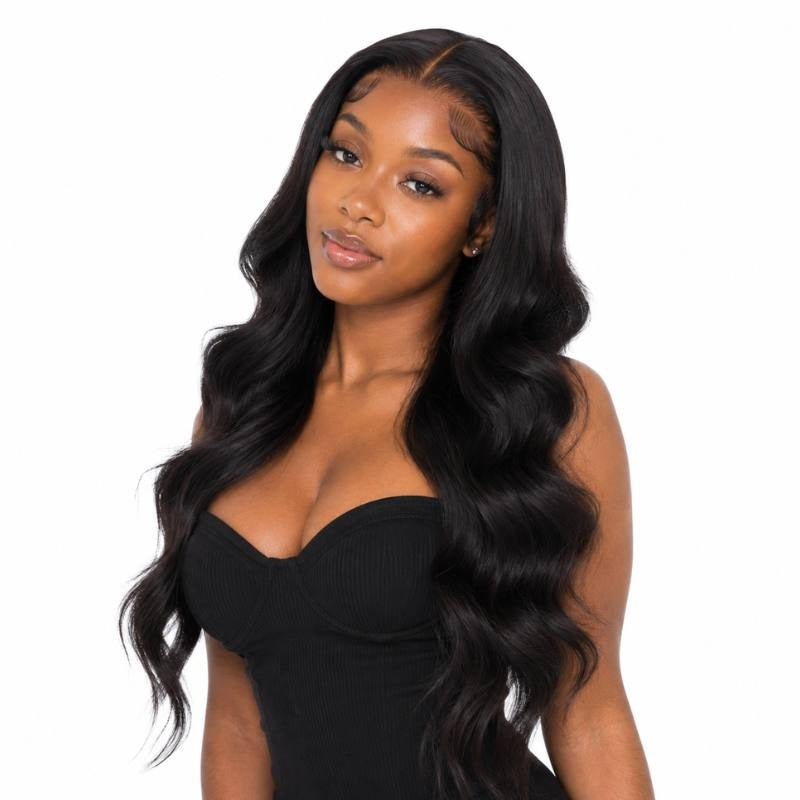 Model with head tilted wearing a long body wave natural black human hair wig with a side part and waves falling down the front