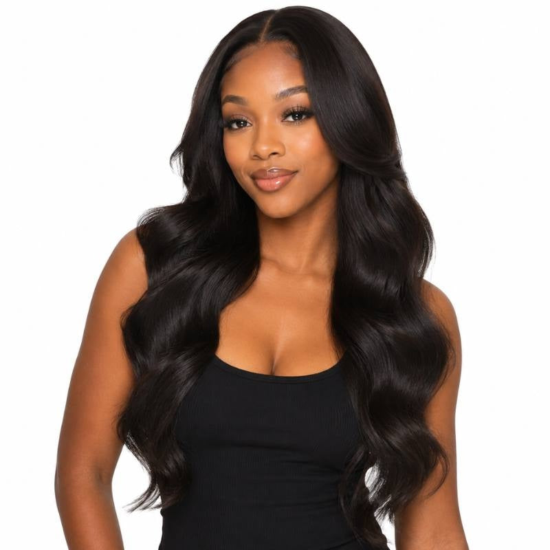 Model smiling at the camera in a long body wave natural black human hair wig with a middle part and waves framing her shoulders