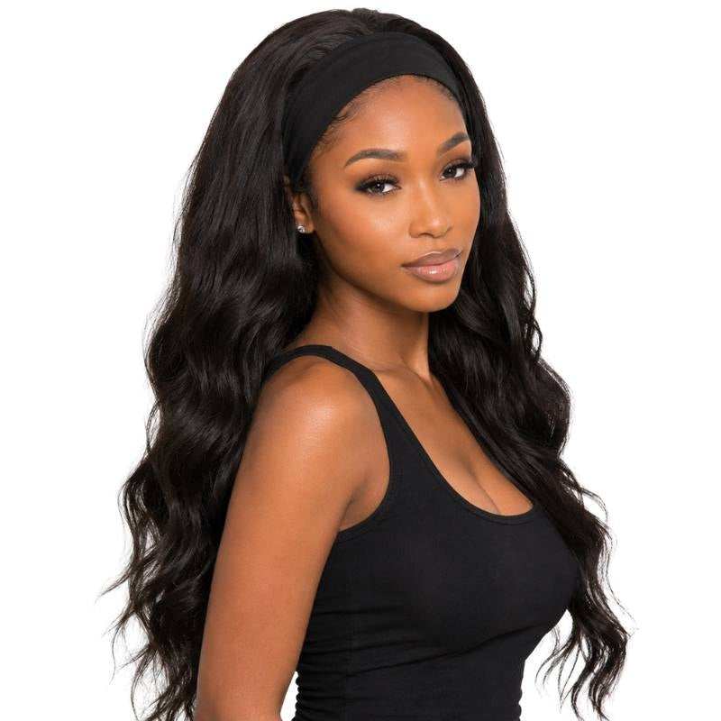 Model at an angle wearing a body wave natural black headband human hair wig with long waves and the band sitting at the hairline
