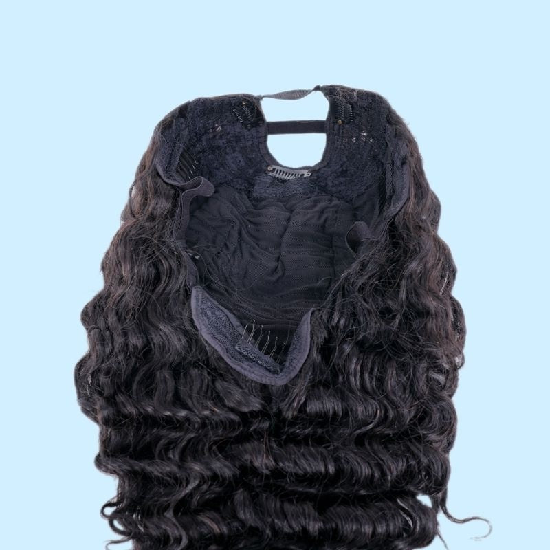 Interior of the cap on a natural black deep wave human hair wig held open to show the combs and adjustable band inside