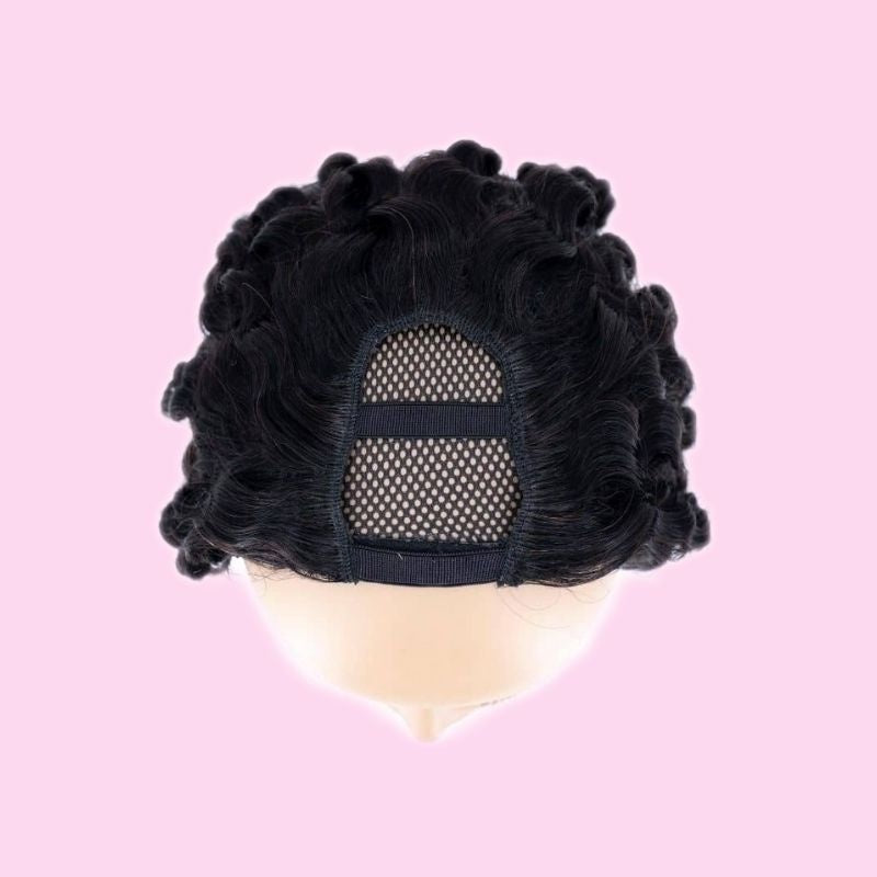 Natural black deep wave human hair wig viewed from above on a pink backdrop with the U shaped mesh opening at the crown