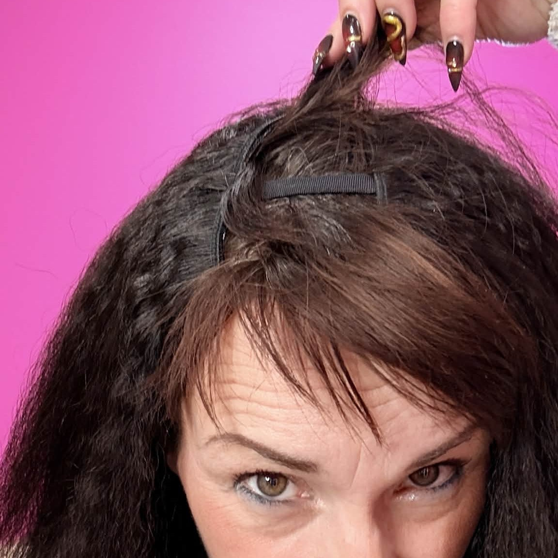 Model showing u-part opening on 12 inch kinky straight human hair wig with hand pulling hair to reveal clip mechanism