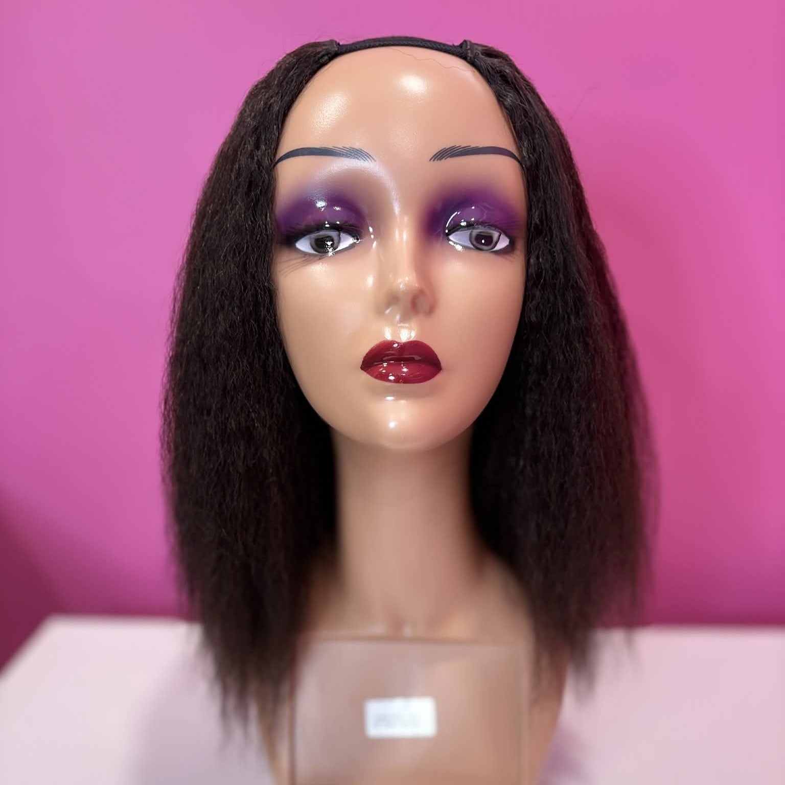 Front alternate view of 12 inch kinky straight u-part human hair wig on mannequin with business card showing texture and fit
