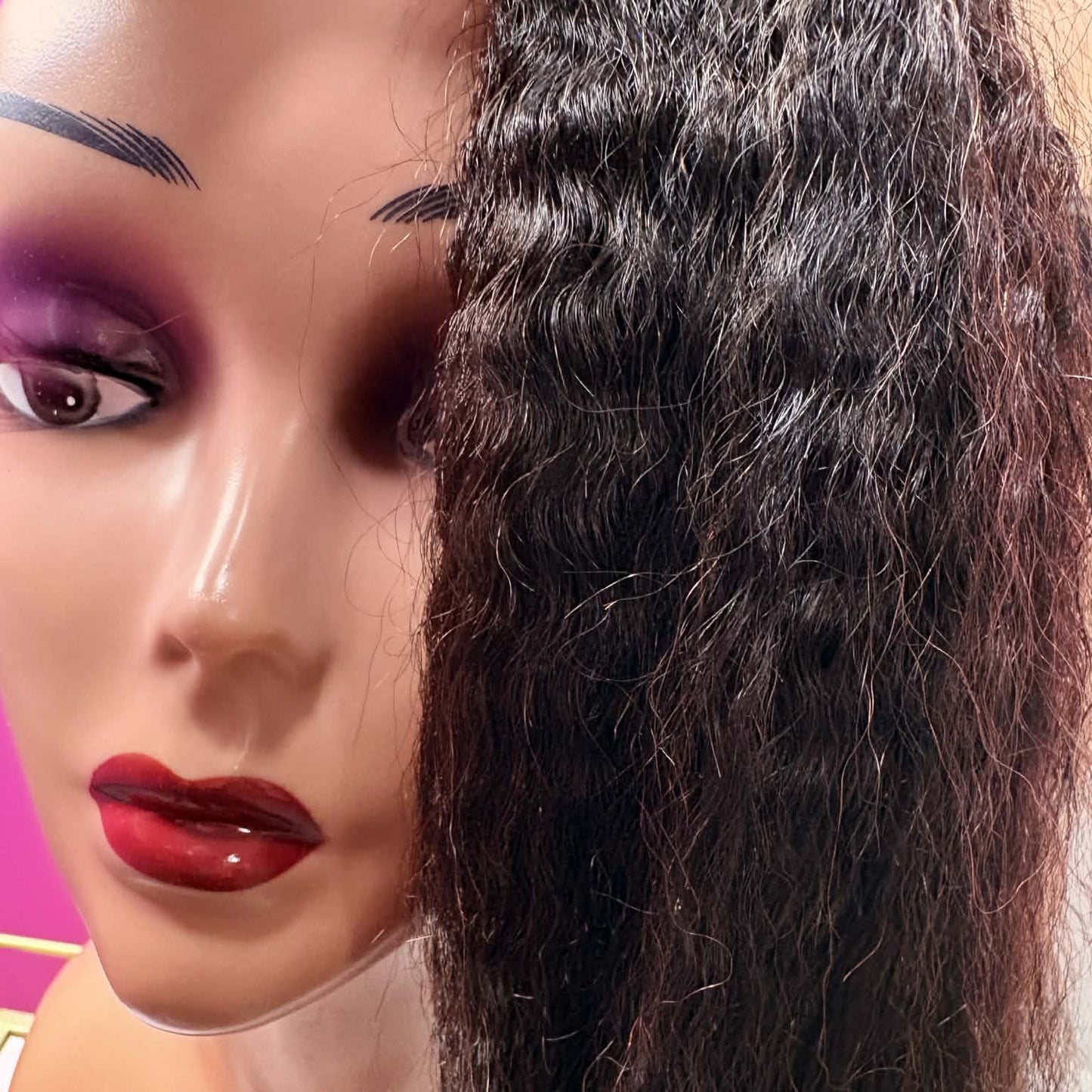 Close-up of mannequin wearing 12 inch kinky straight u-part human hair wig with business card showing face-framing texture