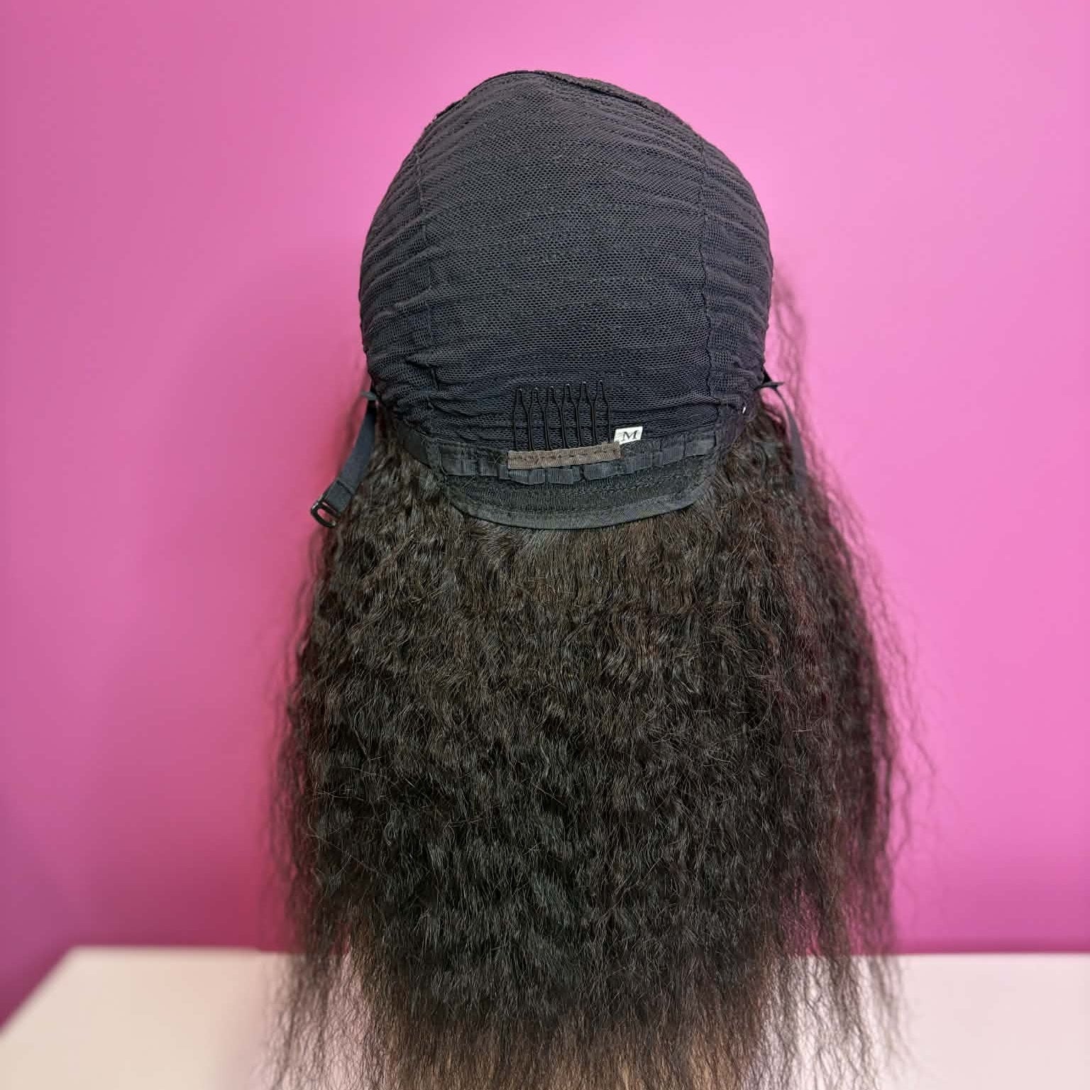 Back view of model wearing 12 inch kinky straight u-part human hair wig showing natural hair blending through u-part opening
