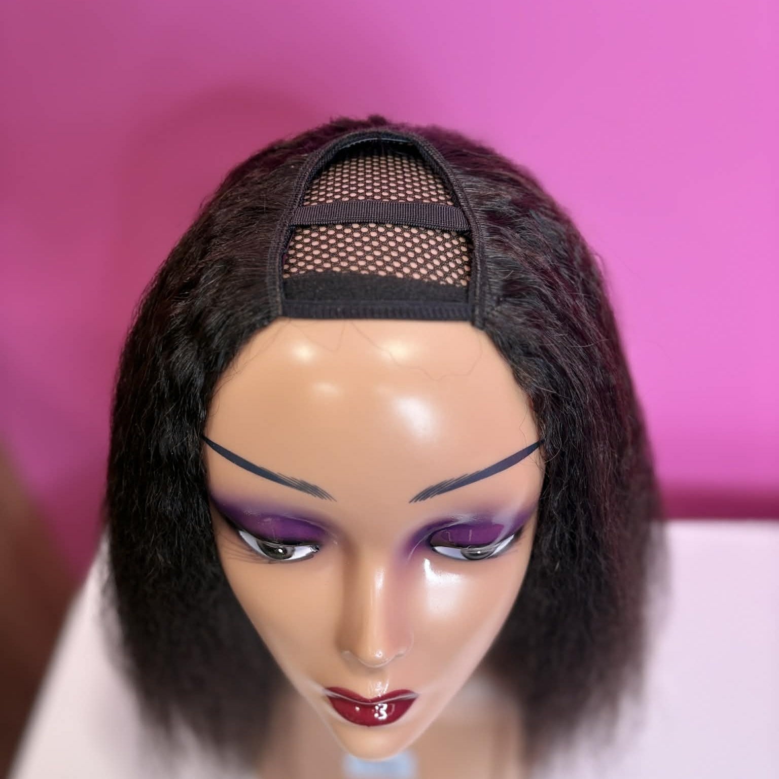 Close-up of u-part opening on 12 inch kinky straight human hair wig showing mesh construction for natural hair pull-through