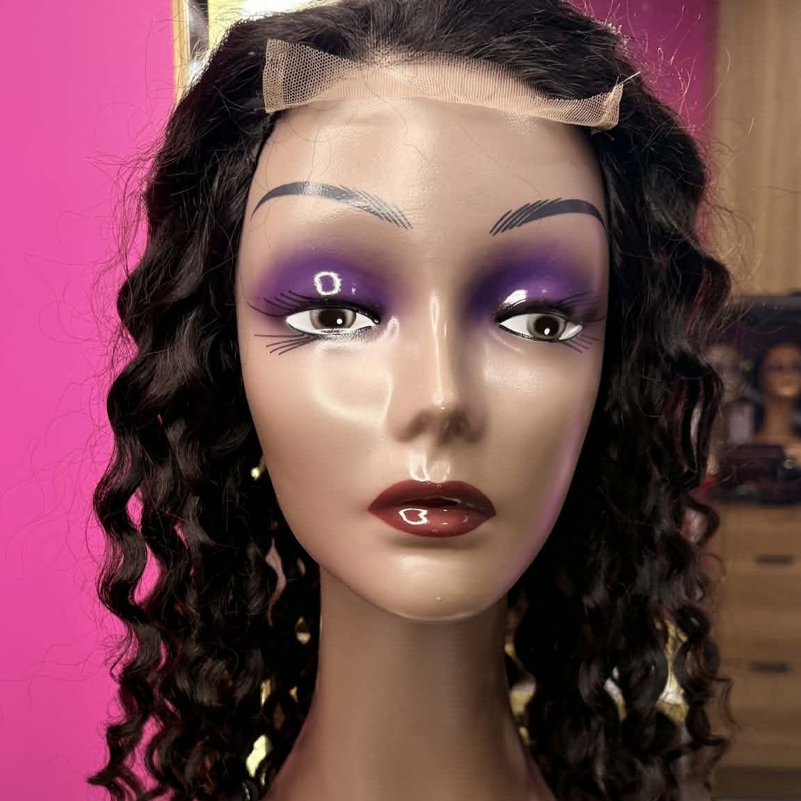 Front view of 22 inch deep wave 13x4 HD lace front human hair wig on mannequin showing transparent lace frontal and spiral curls framing face