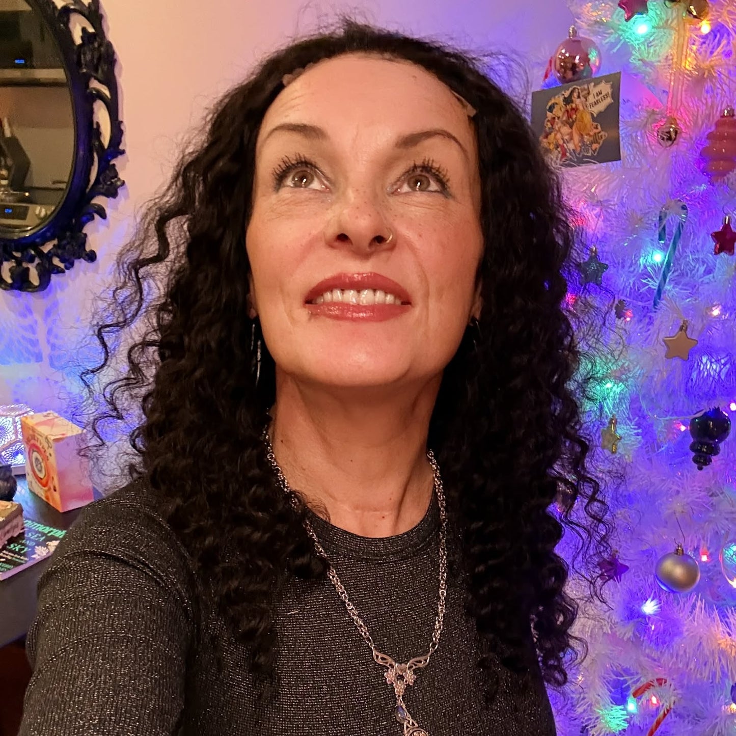 Selfie wearing 22 inch deep wave lace front human hair wig in front of Christmas tree showing festive styling with curls