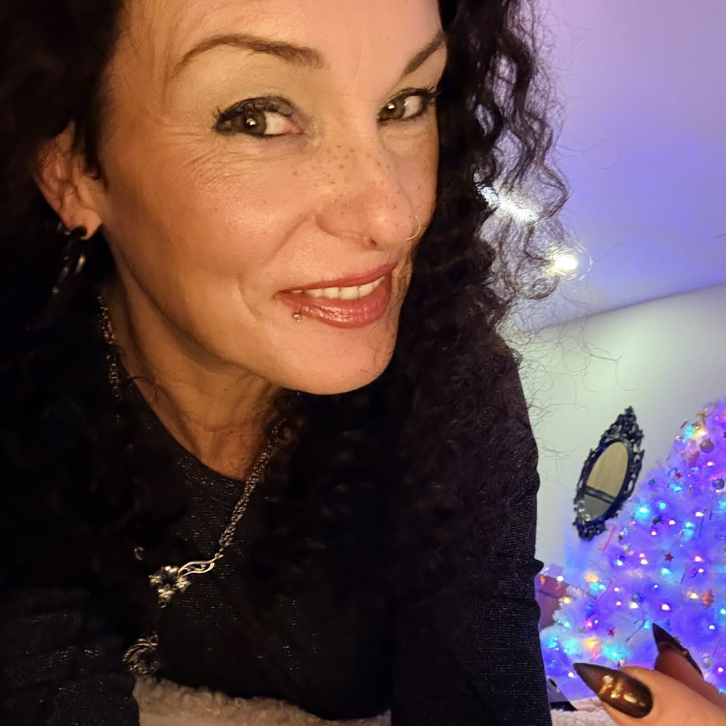 Selfie wearing 22 inch deep wave lace front human hair wig showing nails and curls with holiday decor background