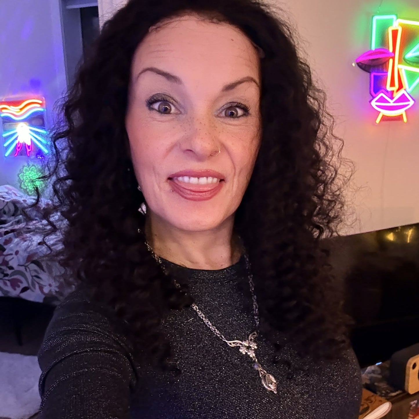 Selfie wearing 22 inch deep wave lace front human hair wig in living room with neon signs showing full curl volume