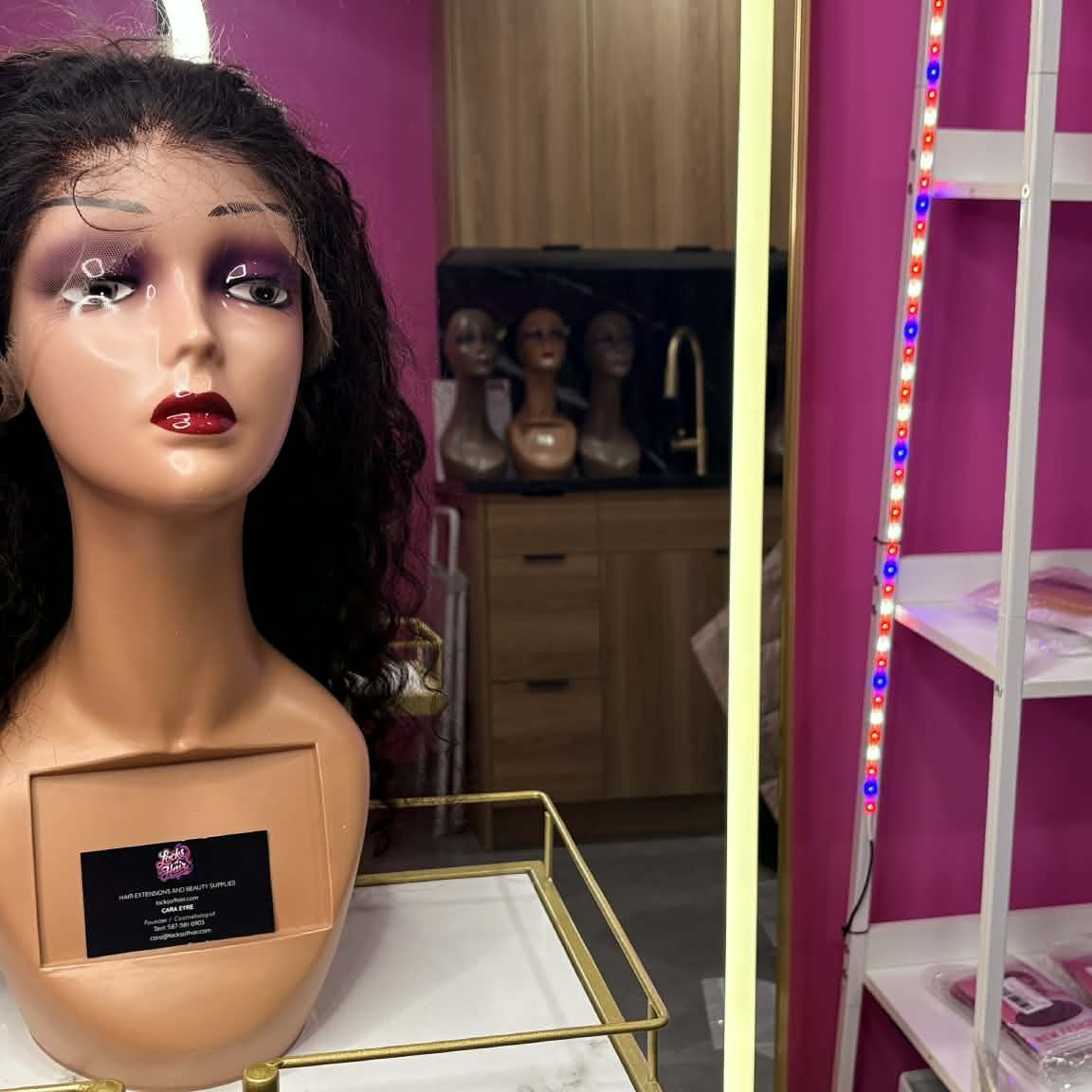 Wide showroom shot of 22 inch deep wave lace front human hair wig on mannequin showing full display with shelving and lights