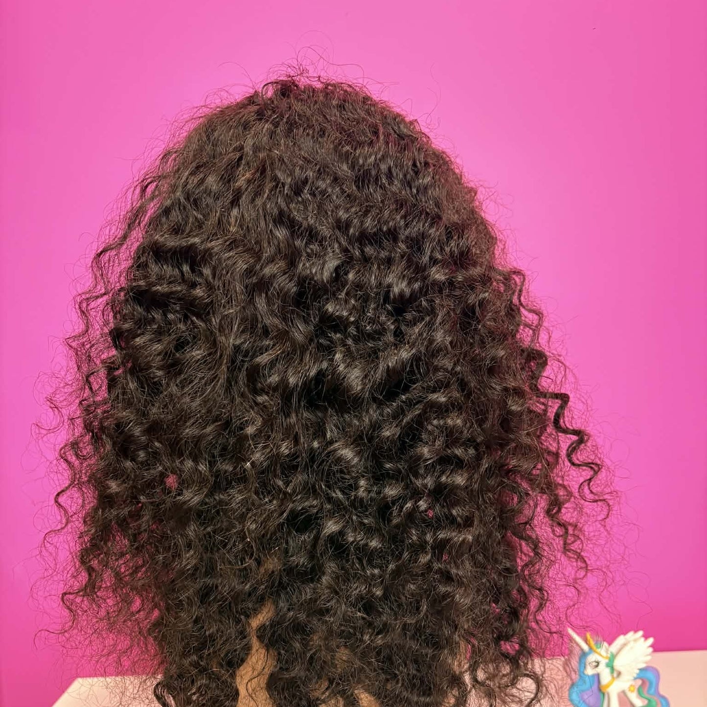 Back view of 16 inch deep wave 4x4 closure human hair wig on mannequin showing spiral curl pattern and length