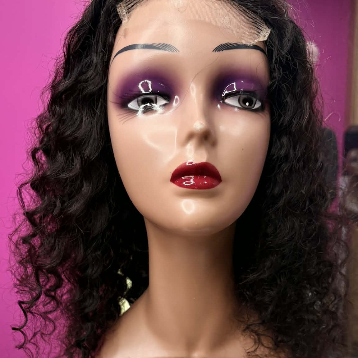 Front view of 16 inch deep wave 4x4 closure human hair wig on mannequin with product label showing lace closure and curls