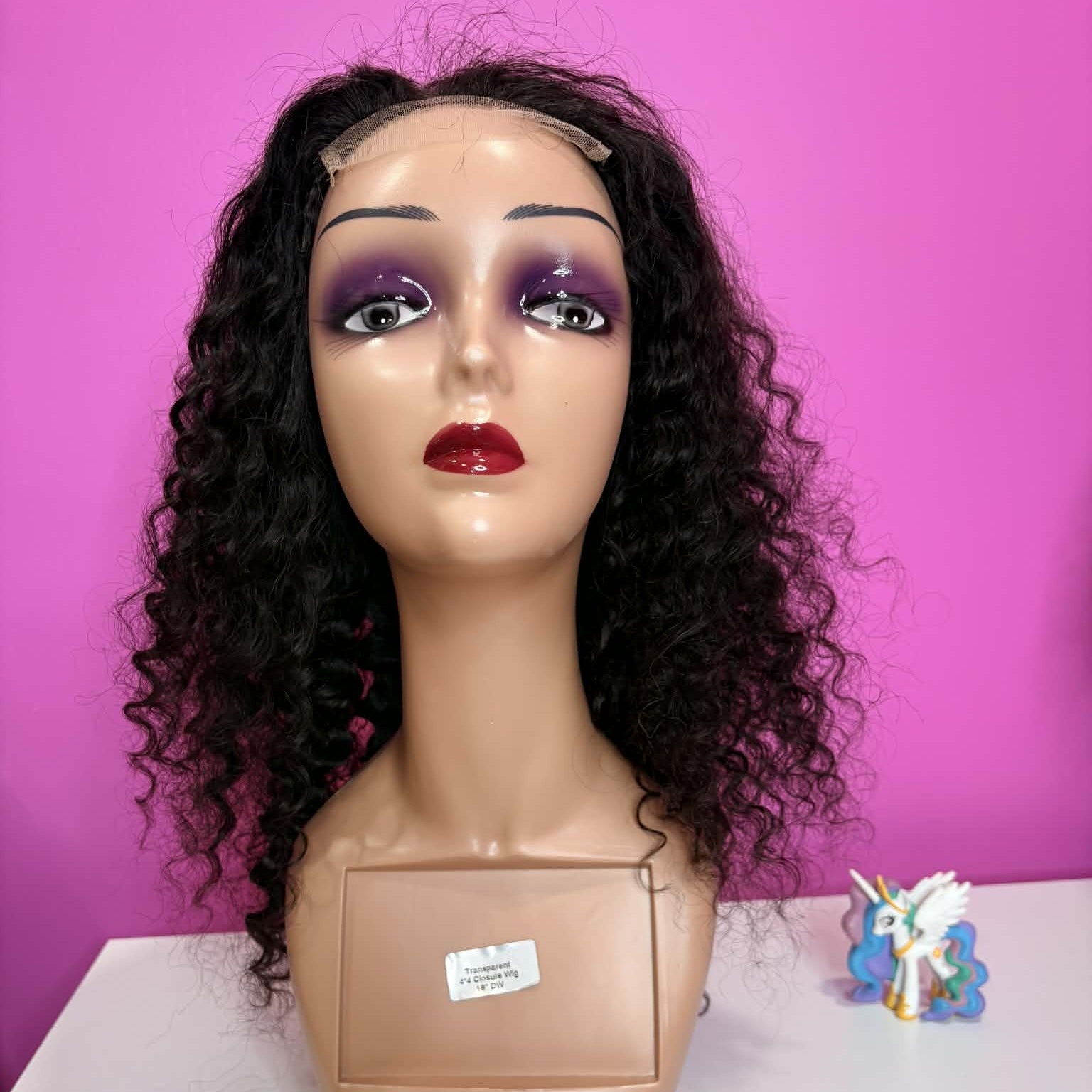 Front view of 16 inch deep wave 4x4 closure human hair wig on mannequin showing lace closure parting and curl framing