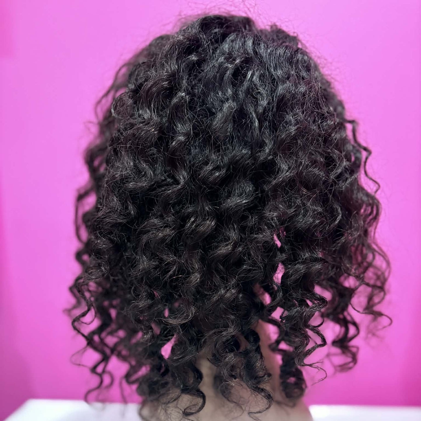 Back view of 14 inch deep wave headband human hair wig in natural black on mannequin showing full curl pattern and volume