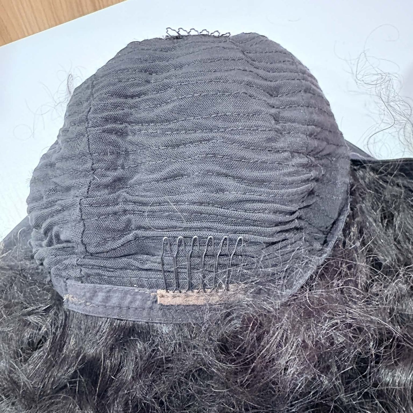 Interior back view of 14 inch deep wave headband human hair wig cap showing combs and breathable weft construction
