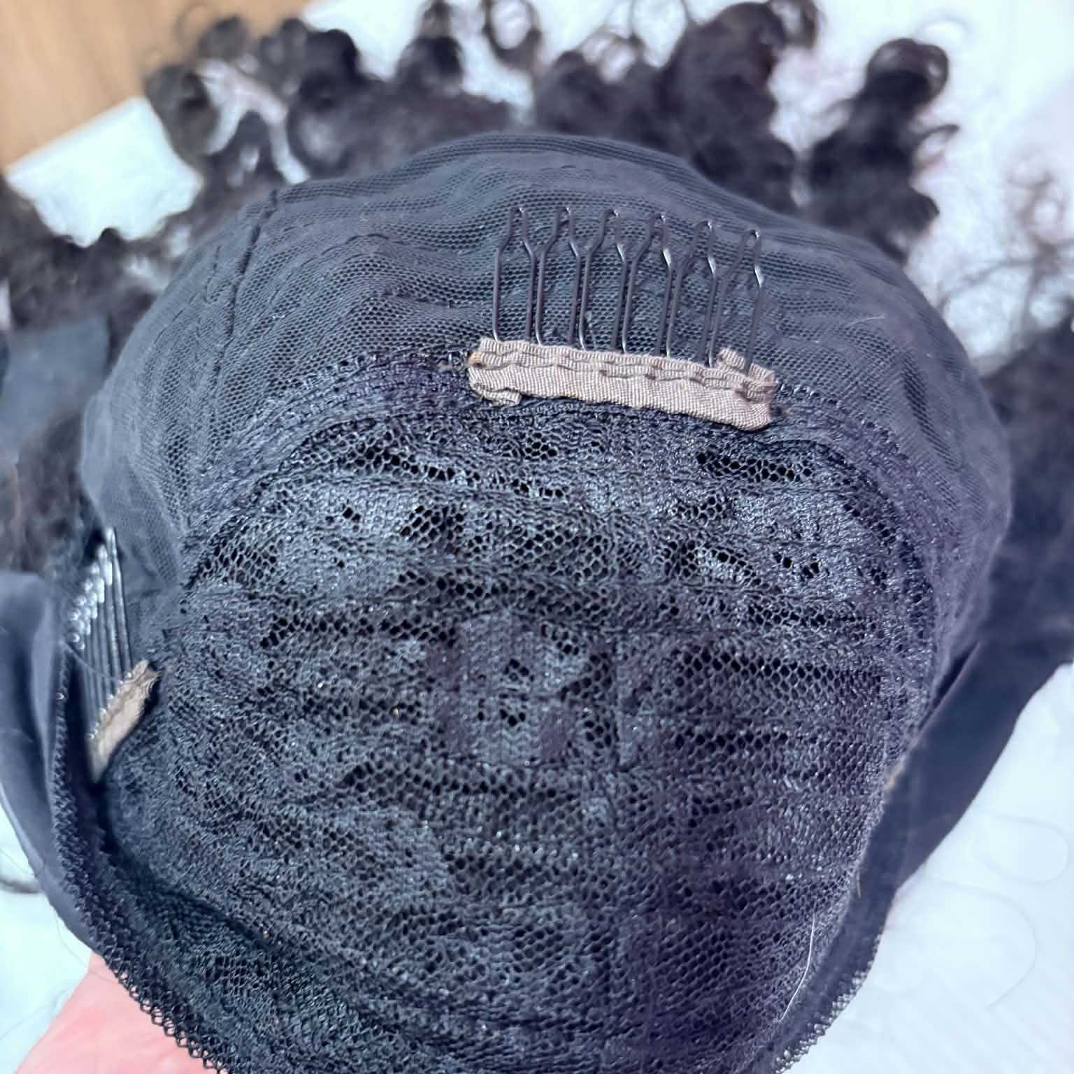 Hand-held interior view of 14 inch deep wave headband human hair wig showing full cap construction with comb and lace mesh