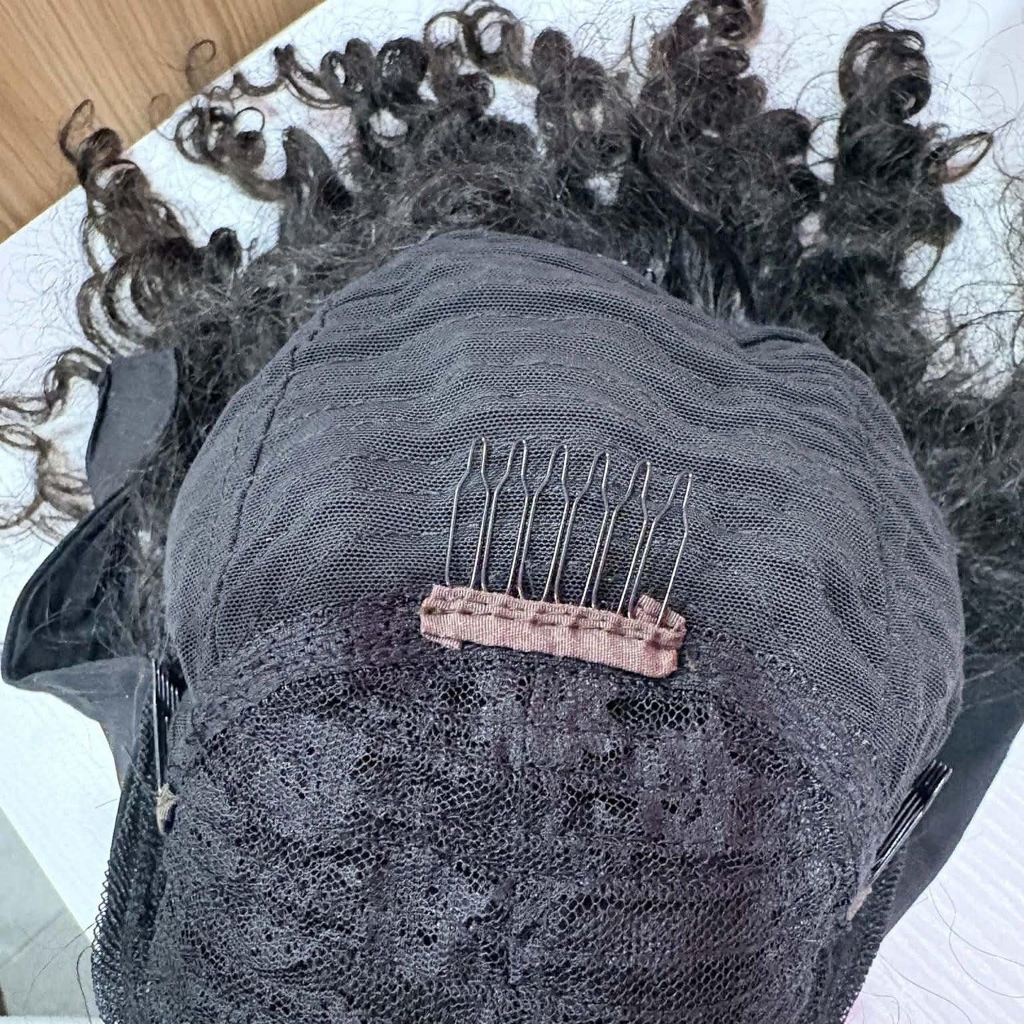Interior top view of 14 inch deep wave headband human hair wig showing securing comb and lace mesh cap detail