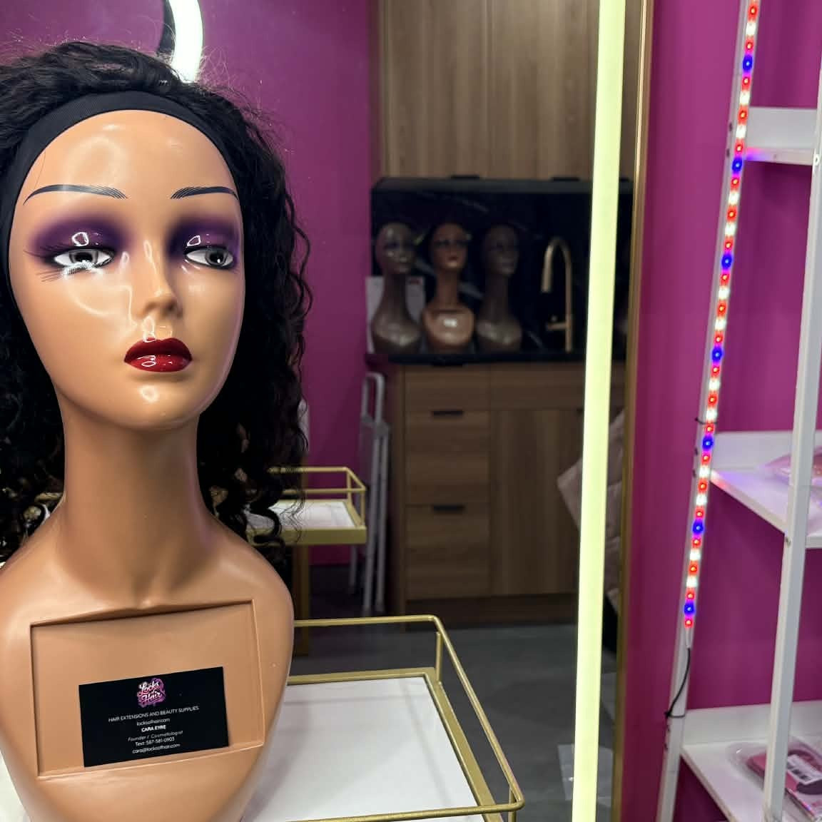 Front view of 14 inch deep wave headband human hair wig on mannequin in showroom with business card showing headband and face-framing curls