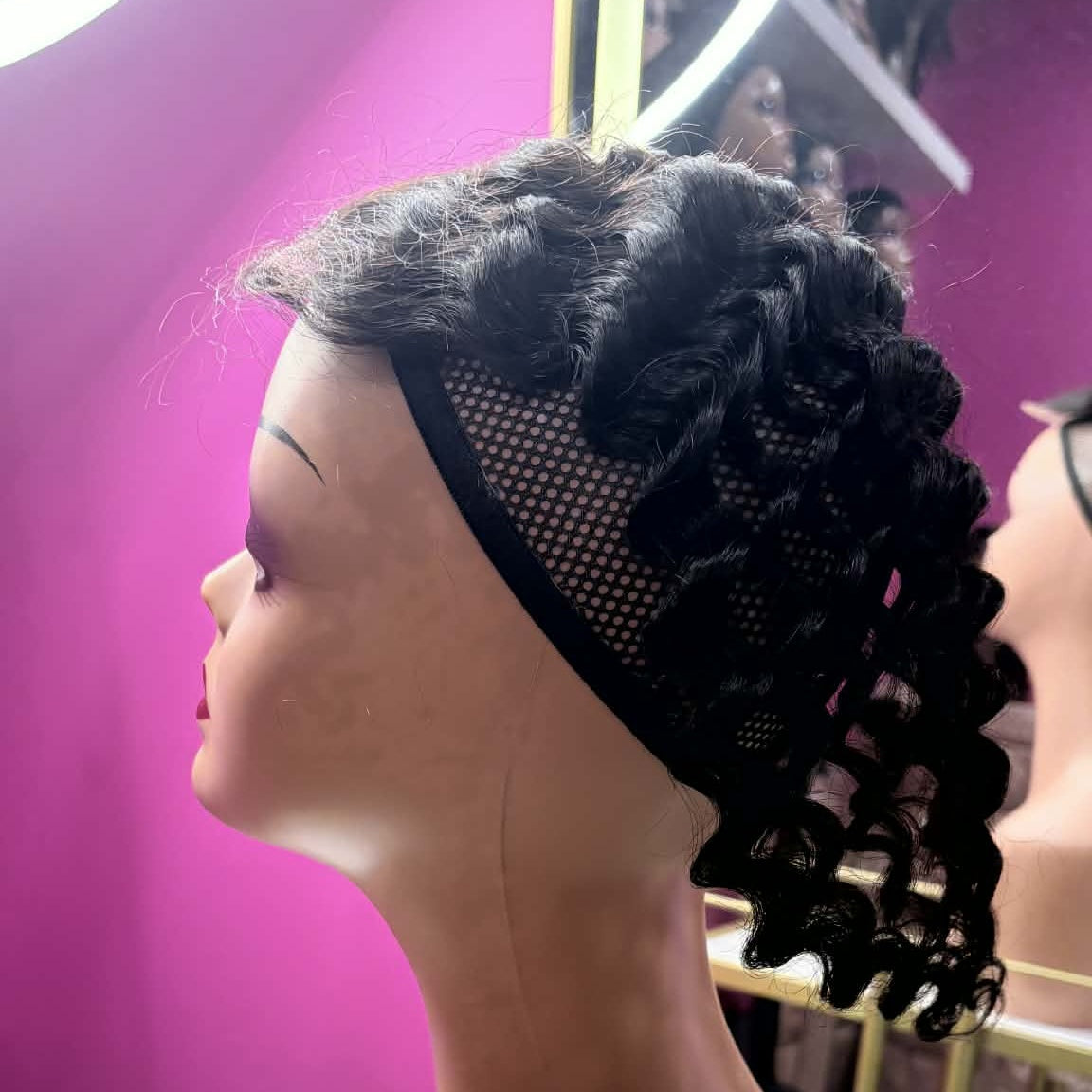 Left side profile of 14 inch deep wave headband human hair wig on mannequin showing black headband detail and deep wave curls pinned up