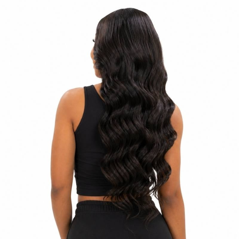 Back view of a model wearing a natural black body wave human hair wig with the waves running the full length past the waist