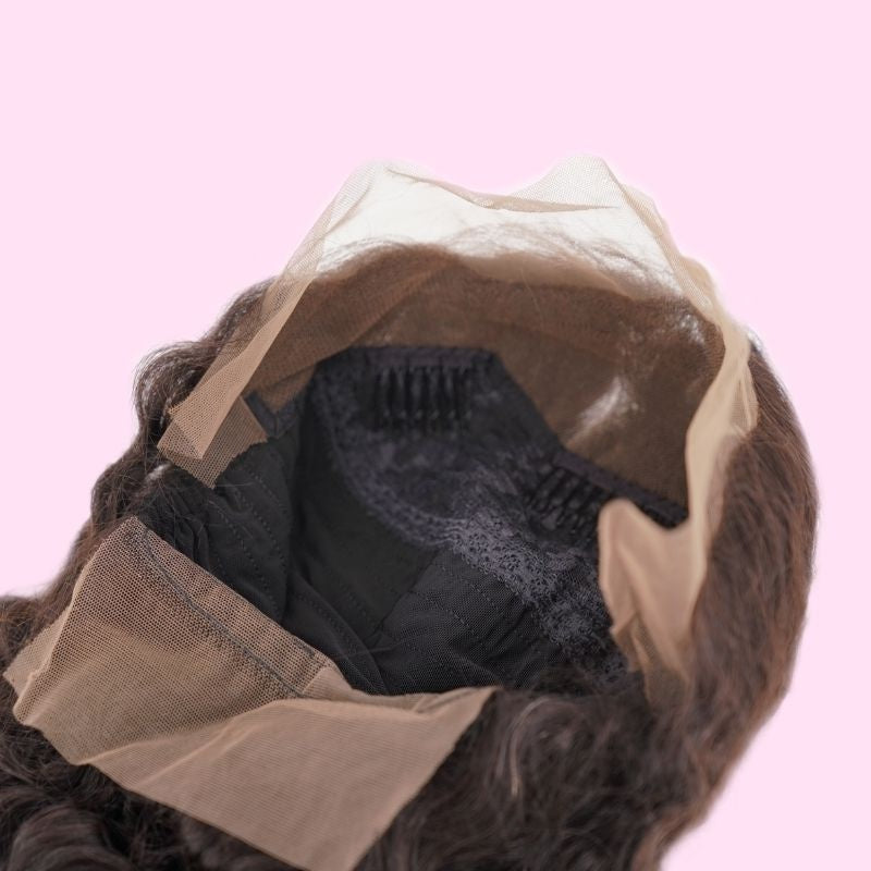 Interior of a loose wave human hair wig cap held open showing the lace panel, a comb and the elastic band inside the crown