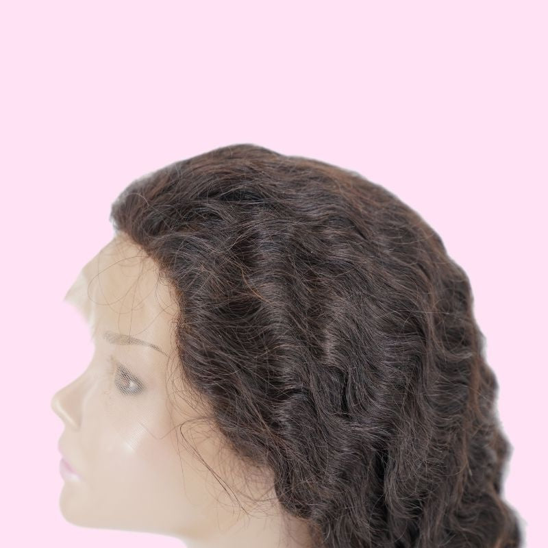 Profile of a natural black loose wave human hair wig on a mannequin head showing the lace edge along the temple and the wave through the crown
