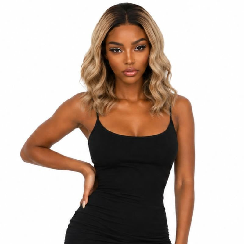 Model standing with a hand on the hip wearing a natural black to platinum blonde ombre body wave bob human hair wig with shadowed roots