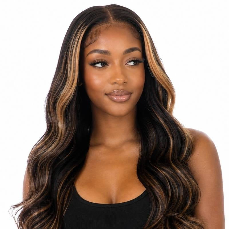 Head and shoulders crop of a model in a natural black body wave human hair wig with honey blonde balayage at the parting and face framing pieces
