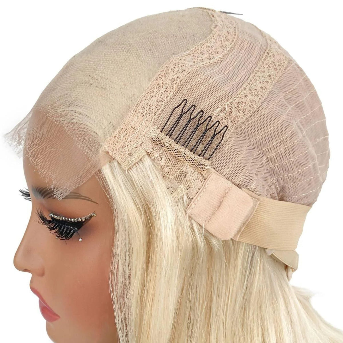 Side of a blonde body wave human hair wig cap on a mannequin showing a comb, the elastic band and light blonde hair below