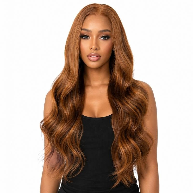 Model wearing a copper body wave human hair wig with a middle part and waves falling past the shoulders on a white background