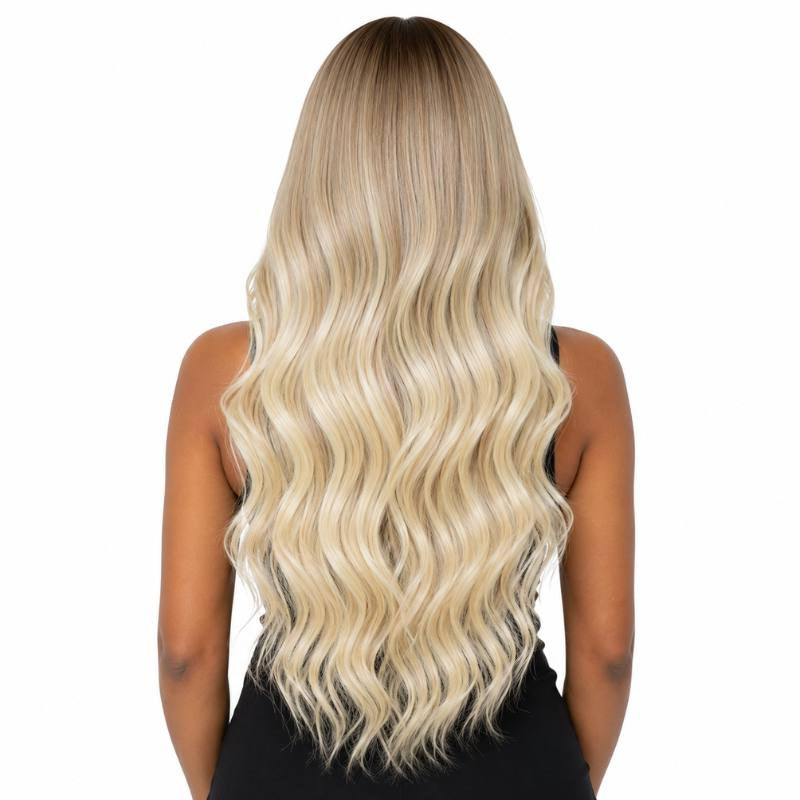 Back view of a model wearing a honey blonde to platinum blonde body wave human hair wig showing the waves down the back
