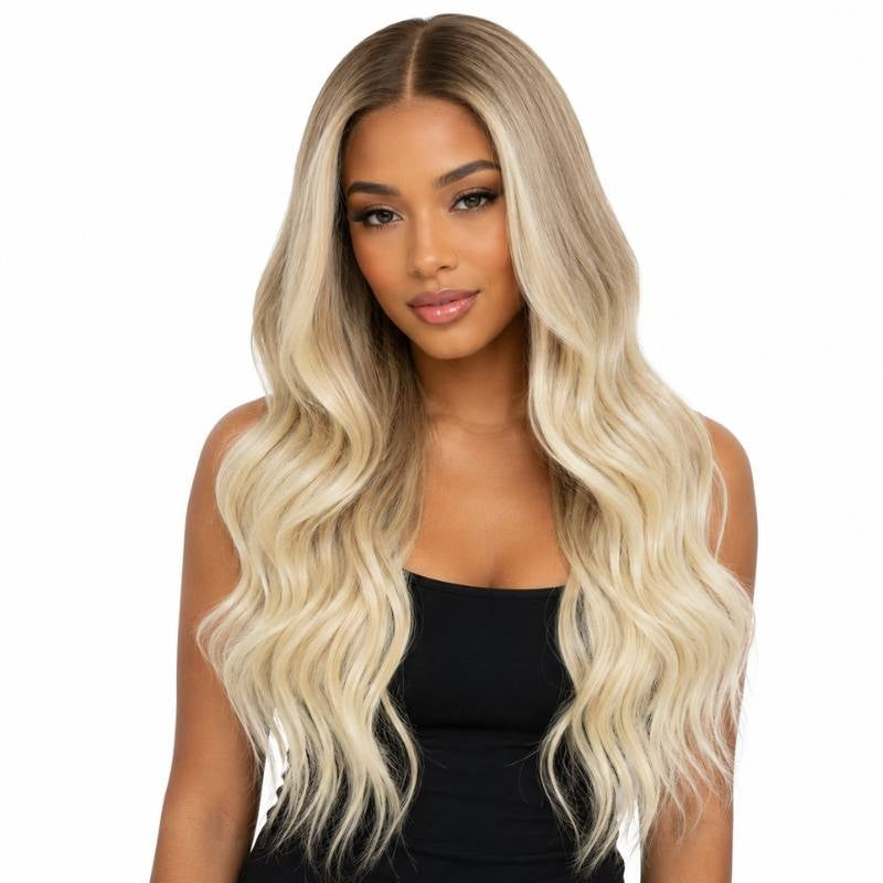 Model wearing a honey blonde to platinum blonde body wave human hair wig with a middle part and waves falling below the chest
