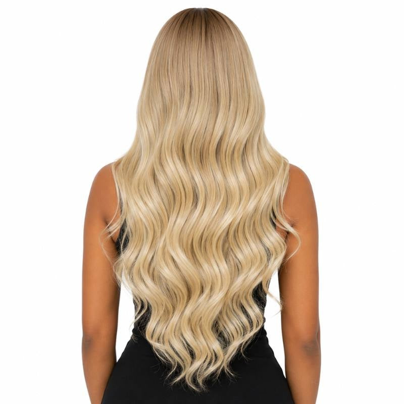Back view of a model wearing a toffee to blonde ombre body wave human hair wig showing the wave pattern down the back