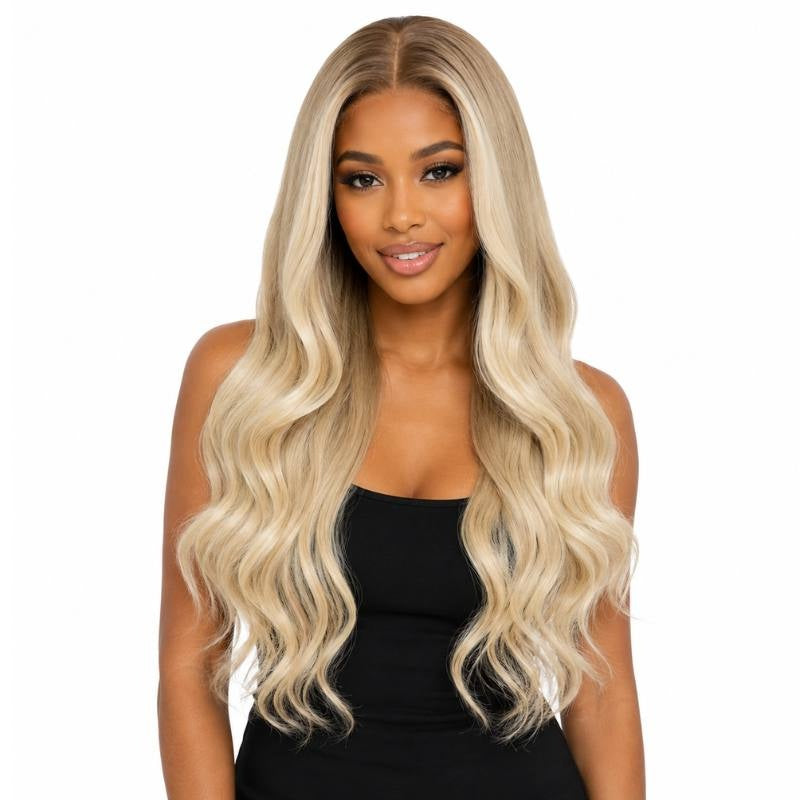 Model wearing a toffee to blonde ombre body wave human hair wig with a middle part and waves falling past the chest