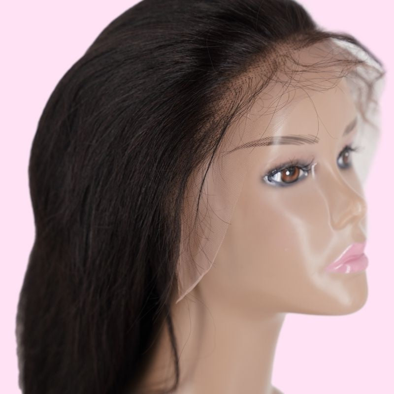 Angled view of a natural black straight human hair wig on a mannequin showing the lace front and hairline against a pink background