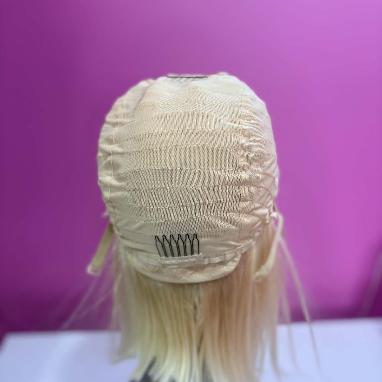 Interior back cap view of 10 inch blonde bob human hair wig showing adjustable straps and cap construction