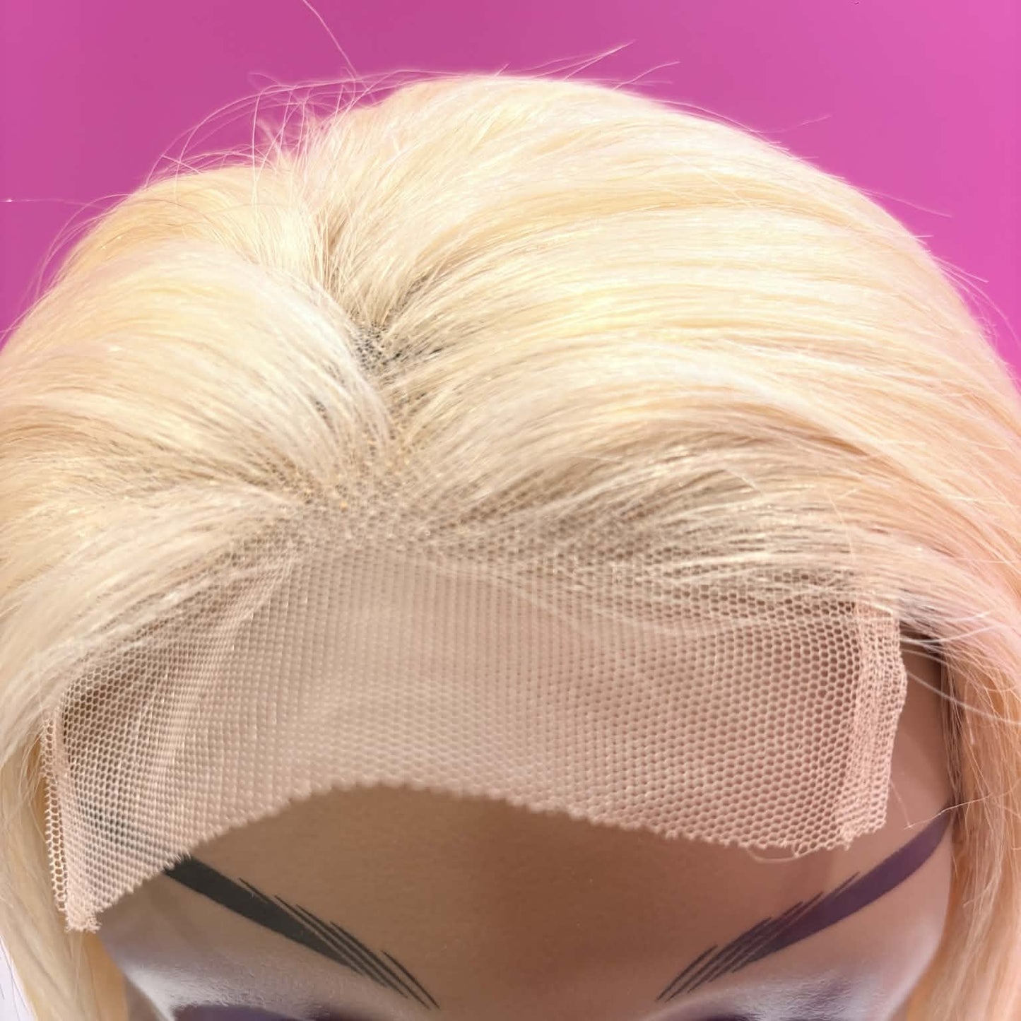 Close-up of 4x4 transparent lace closure on 10 inch blonde bob human hair wig showing lace mesh and parting space