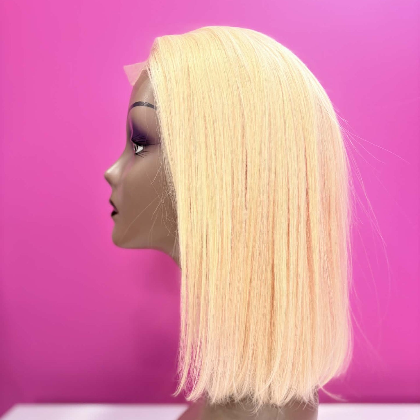 Left side profile of 10 inch blonde 613 straight bob lace human hair wig on mannequin showing blunt cut at jaw line